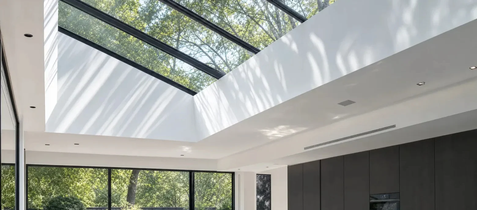 Cobertura de vidro com estrutura escura e entrada de luz natural em residência