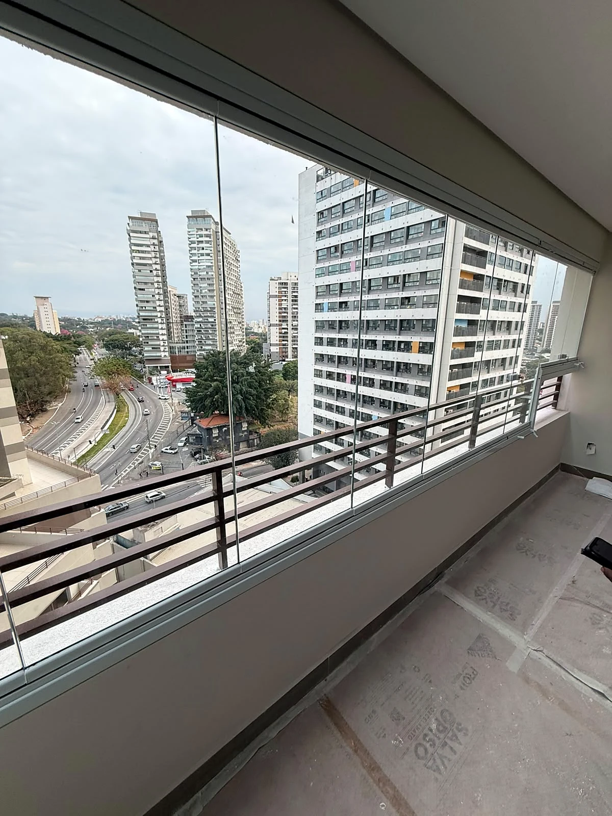 Sacada com guarda-corpo e fechamento em vidro, obra da Salumin